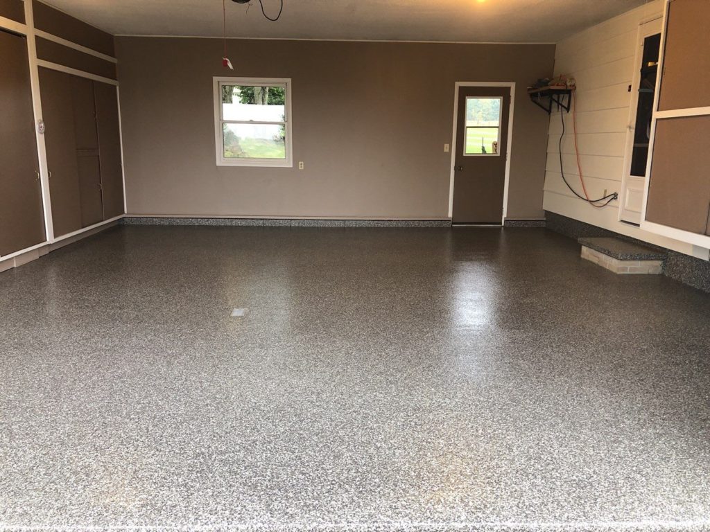 Wide gray flake-coated garage floor with side windows and white walls